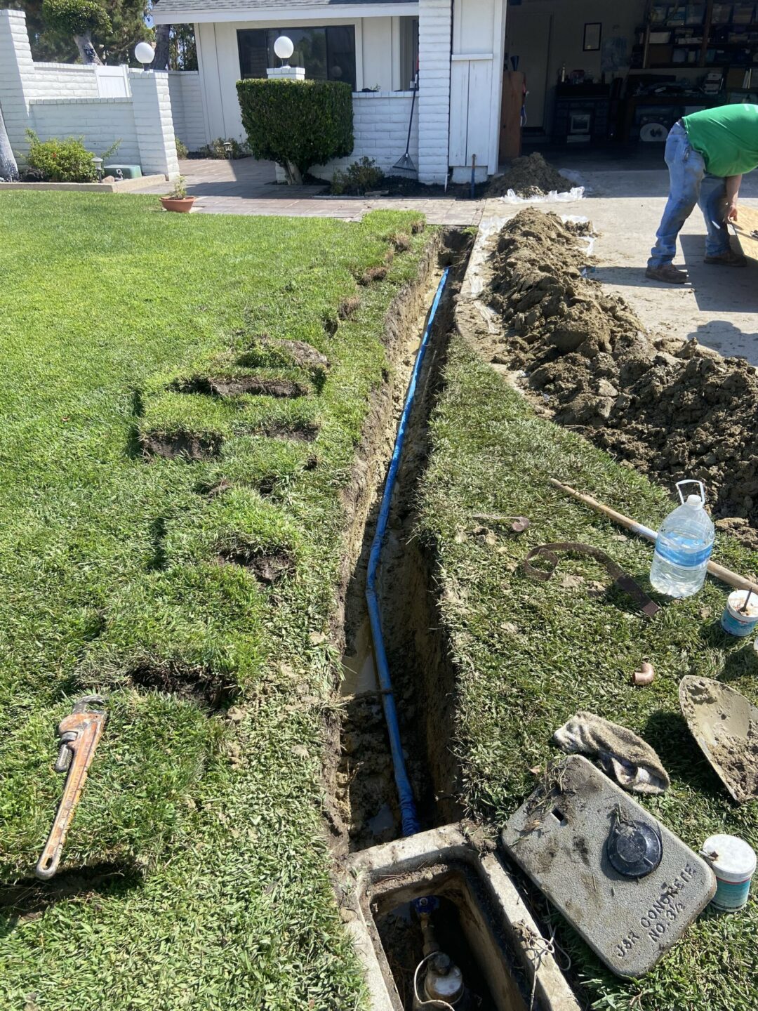 Sewer line replacement in progress with exposed pipes and trench